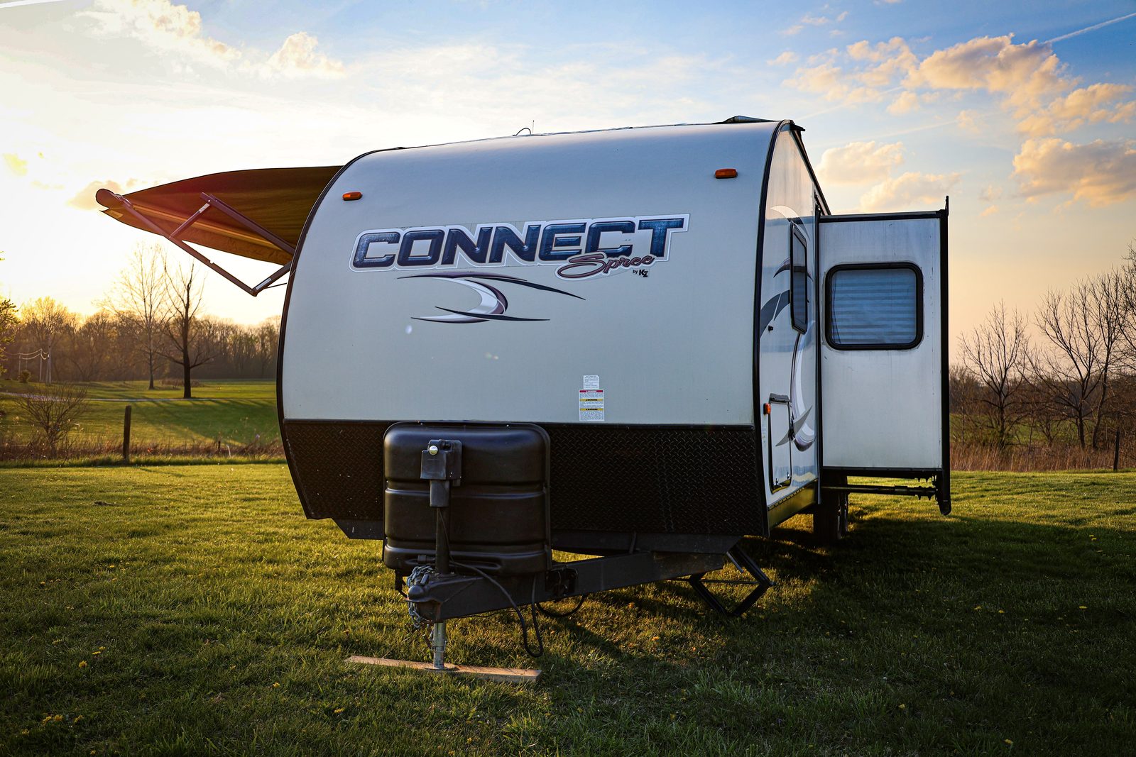 KZ Connect Spree travel trailer at golden hour with the awning out