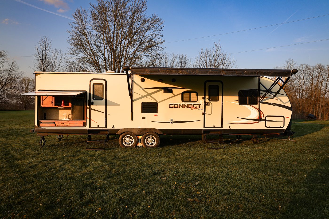 Camper set up at golden hour with the awning open